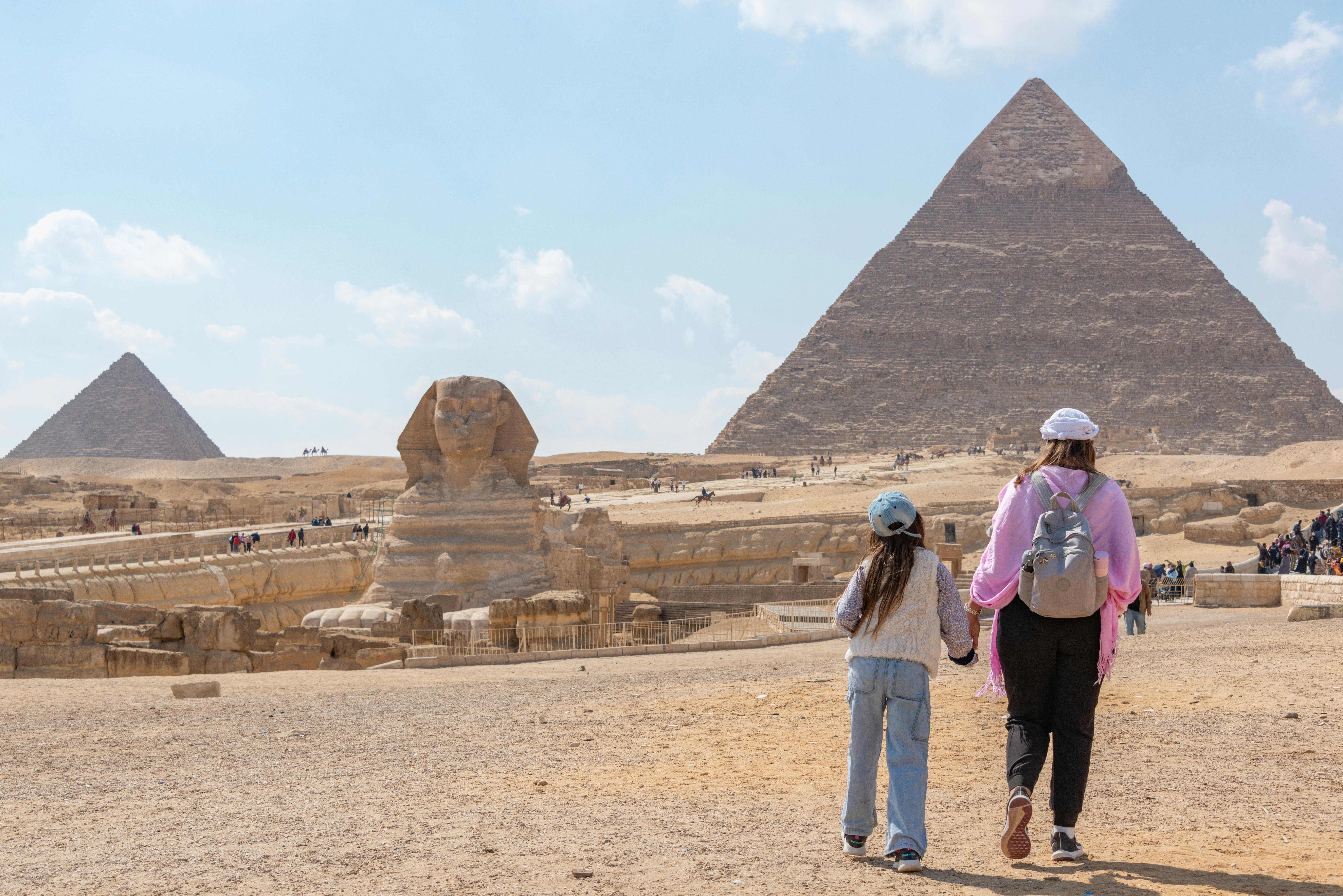 Travelers and camels near the Giza pyramids on an Egypt sightseeing day trip